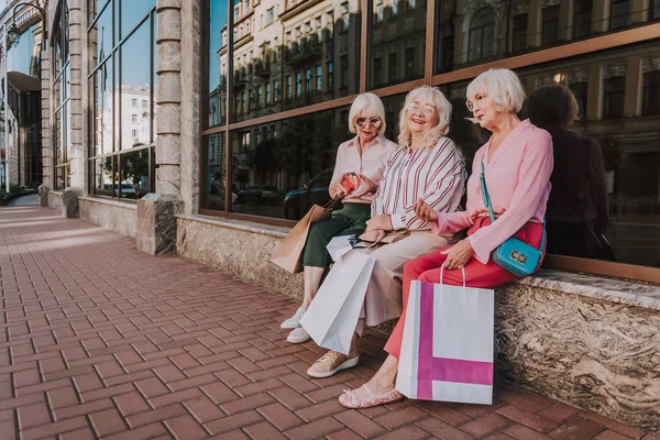 Tres elegantes pensionistas están sentadas cerca del centro comercial — Foto de Stock