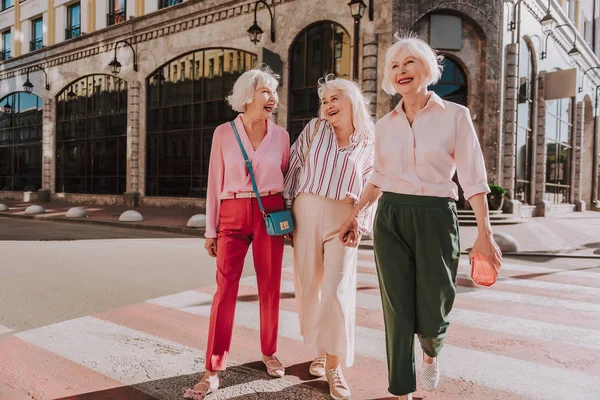 Riendo amigas en edad están cruzando la calle — Foto de Stock
