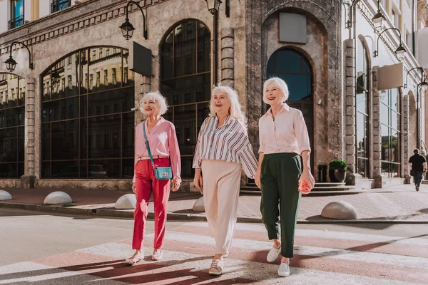 Улыбающиеся взрослые женщины ходят по улицам мегаполиса — стоковое фото