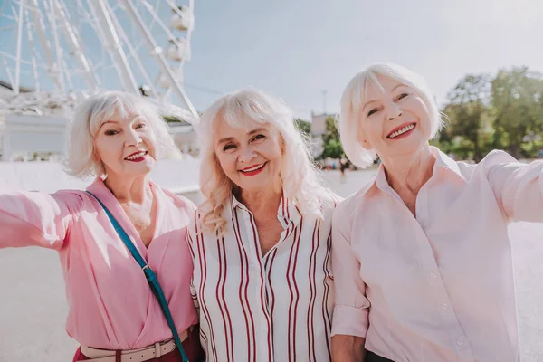 Tres sonrientes señoras mayores están tomando fotos en la cámara — Foto de Stock