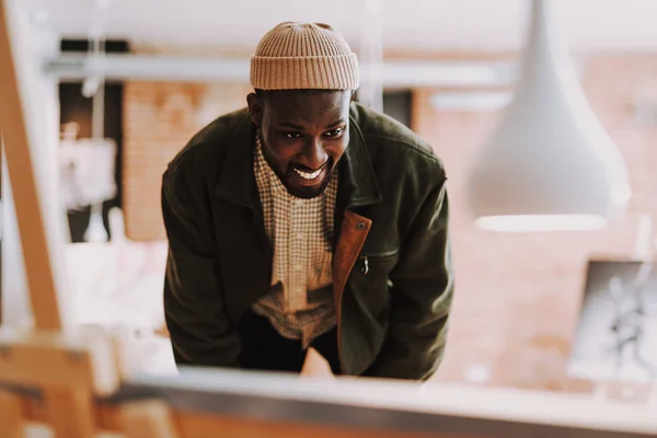 Positieve Afro-Amerikaanse man glimlachend en leunend naar de afbeelding — Stockfoto