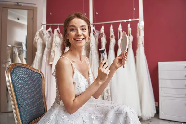 Sorrindo noiva no vestido de noiva fazendo maquiagem — Fotografia de Stock