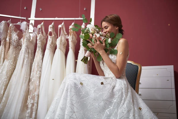 Noiva feliz no vestido de noiva farejando flores — Fotografia de Stock