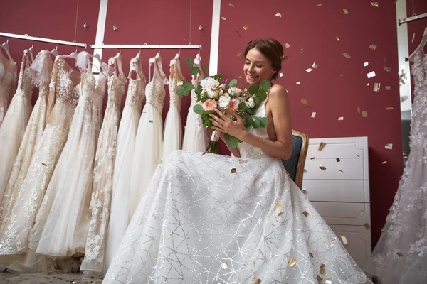 Smiling bride in wedding salon with flowers