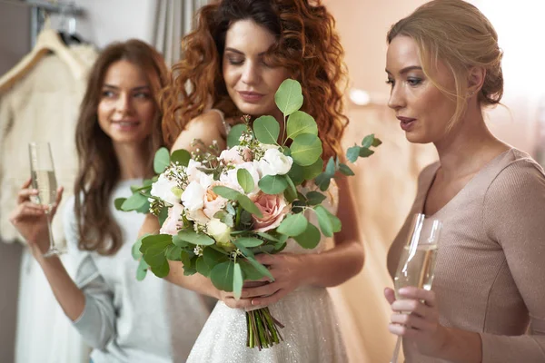 Jovens senhoras felizes olhando para a flor da futura noiva — Fotografia de Stock