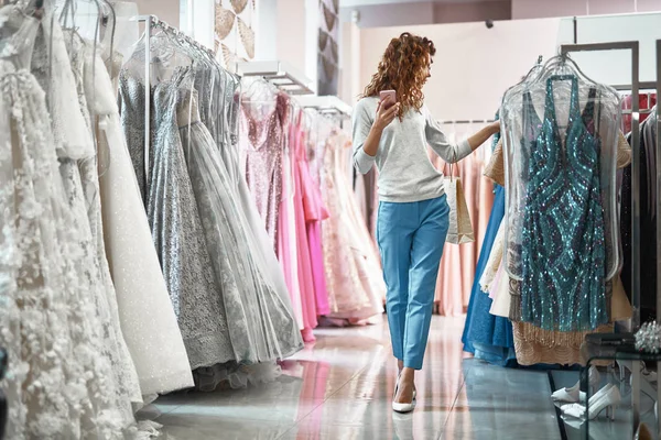 Jeune femme choisir robe dans le salon de mariage — Photo