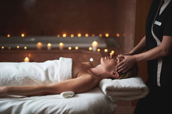 Therapist make anti-age face massage to lady