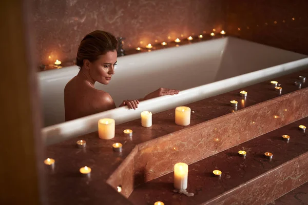 Молода дама приймає спокійну спа-ванну зі свічкою — стокове фото