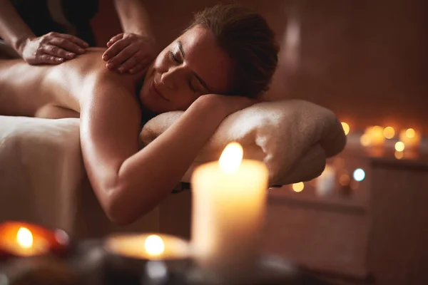 Sorrindo senhora sendo relaxar na mesa de massagem — Fotografia de Stock