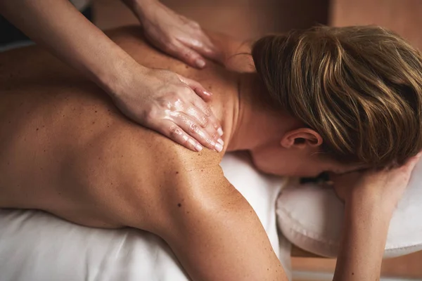 Joven dama teniendo masaje de aceite en el salón de spa — Foto de Stock