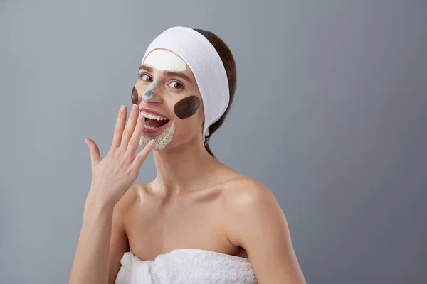 Весела дівчина з різними масками на її обличчі покриває рот рукою — стокове фото