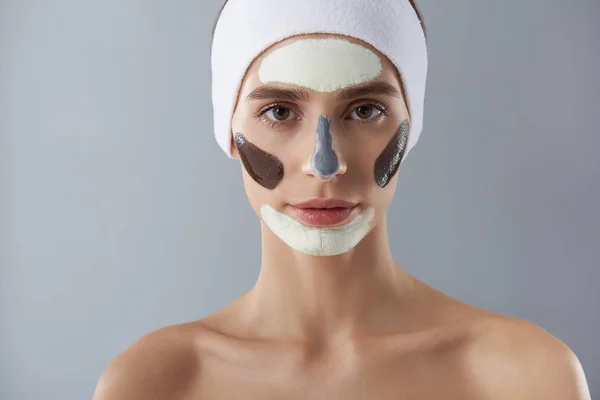 Uroczy młoda kobieta przy użyciu różnych typów twarzy maski — Zdjęcie stockowe