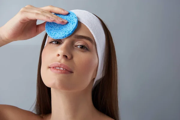 Gadis cantik dengan ikat kepala putih menggunakan spons biru — Stok Foto