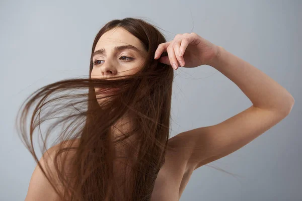 Krásná dívka s dlouhé rovné vlasy vystupují proti světle modré pozadí — Stock fotografie