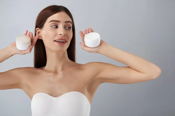 Joyful vacker dam i vit BH visar kosmetiska produkter — Stockfoto