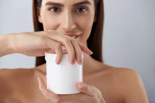 Mooie jonge dame houdt van witte pot met cosmetische crème — Stockfoto