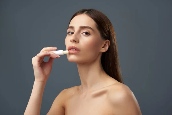 Attraktive junge Dame mit schönen vollen Lippen mit hygienischem Lippenstift — Stockfoto