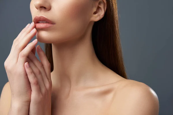 Mujer joven con hermosos labios llenos posando sobre fondo azul-gris —  Fotos de Stock