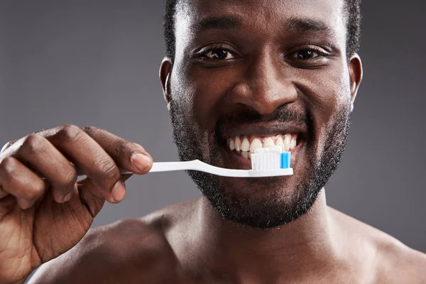 Primer plano de un alegre afroamericano cepillándose los dientes —  Fotos de Stock