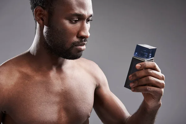 Allvarlig stilig afro amerikansk man undersöker en Köln flaska — Stockfoto