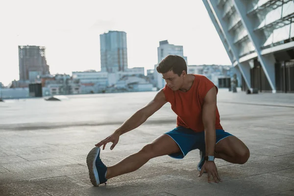 Ordnad unga idrottsutövare stretchening kroppen under dagen — Stockfoto