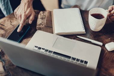 Kupası el ve basın parmak telefon yukarıda tutan adam