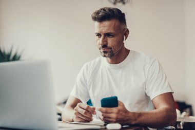 Adam cep ve elinde kalem tutan ve laptop arıyorum