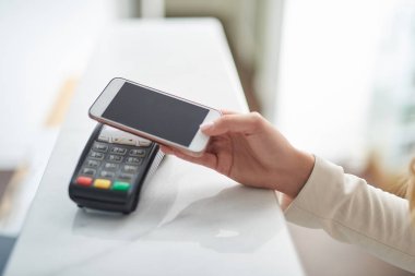 Genç kadın Nfc teknoloji üstünde hareket eden telefon ile ödeme