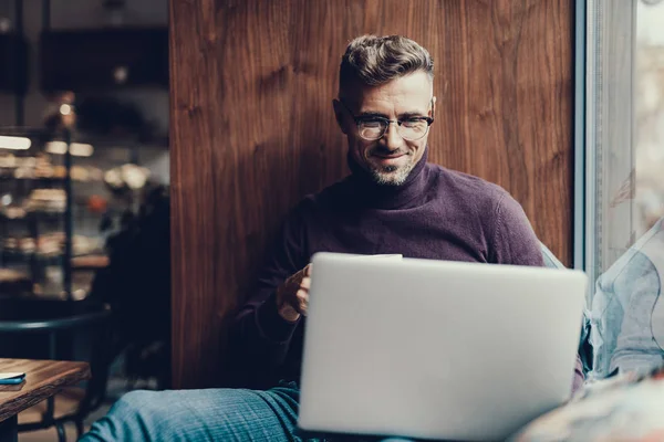 Uomo guardando su netbook monitor e sorridente — Foto Stock