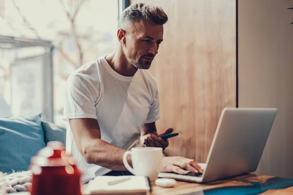 Homme assis dans un café et utilisant un ordinateur portable — Photo