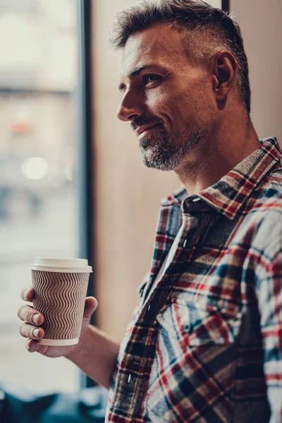 Homme tenant une tasse de café dans les mains et souriant — Photo