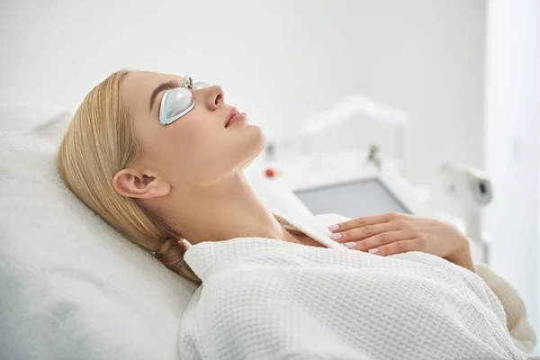 Menina encantadora em óculos de prata descansando no armário cosmetologist — Fotografia de Stock