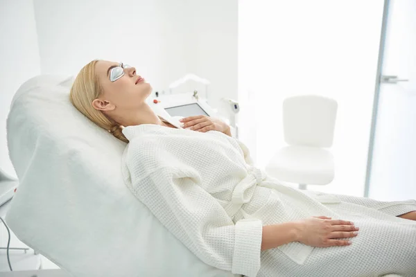 Encantadora chica con gafas descansando en el gabinete cosmetólogo — Foto de Stock