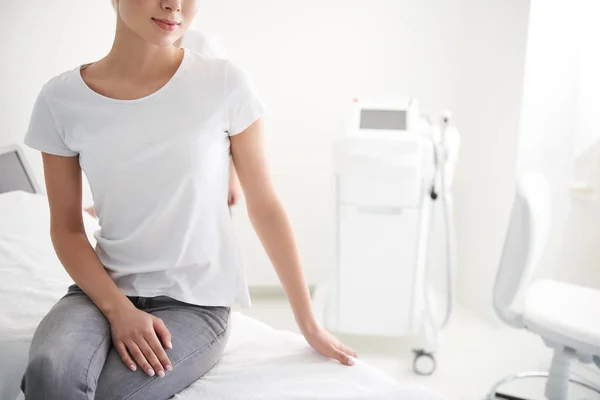 Jonge dame zittend op daybed in Wellness-centrum — Stockfoto