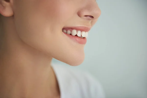 Jovem senhora com pele lisa perfeita sorrindo no fundo azul claro — Fotografia de Stock