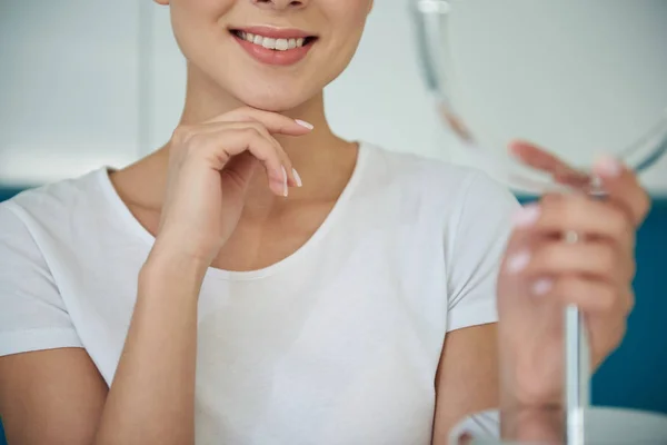 Молодая женщина с красивой улыбкой держа подбородок на руке — стоковое фото