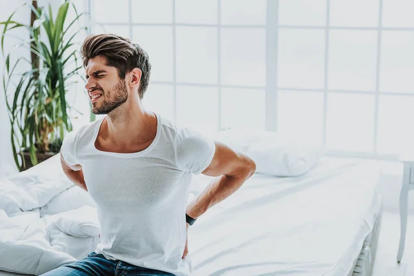 Joven se despierta con dolor de espalda en la mañana — Foto de Stock