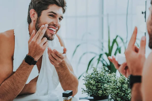 Heureux jeune homme prenant soin de sa peau — Photo