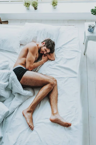 Joven tensión masculina sensación de dolor en la cama — Foto de Stock