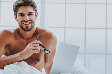 Gülümseyen erkek dizüstü günü işten sonra geri kalan sahip