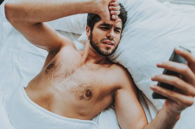 Ssleepy adam göz cep telefonu yatakta döşeme