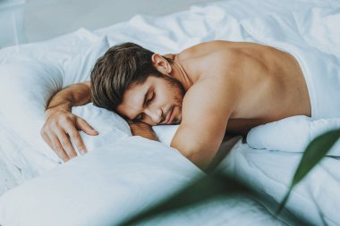 Genç adam yatakta dinlenin ve rüyalar görmek