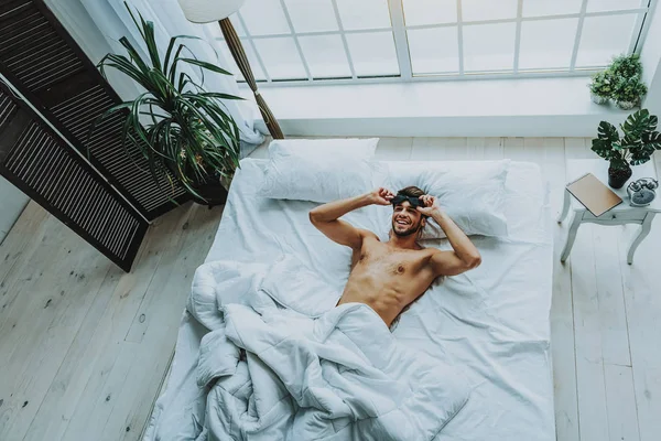 Hombre feliz despertando en la cama en casa —  Fotos de Stock