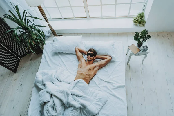 Hombre atractivo descansando con los ojos vendados en la cama —  Fotos de Stock