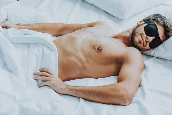 Young handsome man sleep with blindfold in bed