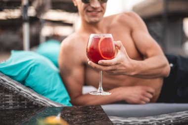 Seçici odak soğuk gömleksiz adam elinde kokteyl