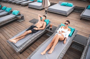 Pozitif çift rahatlatıcı üstten görünüm güneş şezlong üzerinde