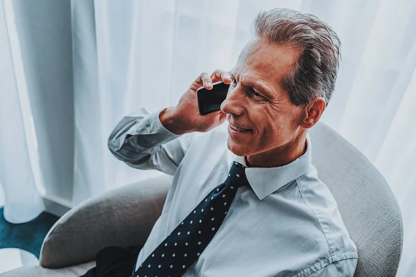 Close up of confident businessman talking on the phone and smiling — Stock Photo, Image