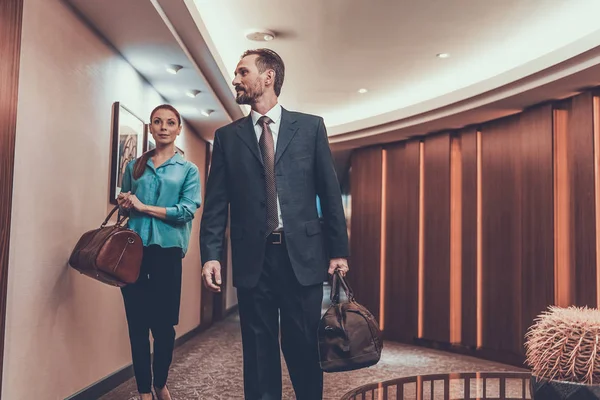 Hombre y mujer caminando con sus maletas en el hotel —  Fotos de Stock