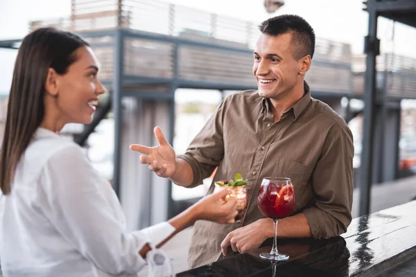 Ekspresyjny człowiek uśmiecha i gestykulacji podczas rozmowy z kobietą — Zdjęcie stockowe